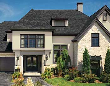 Front view of a a typical mid-class home with charcoal black GAF shingles on its roof